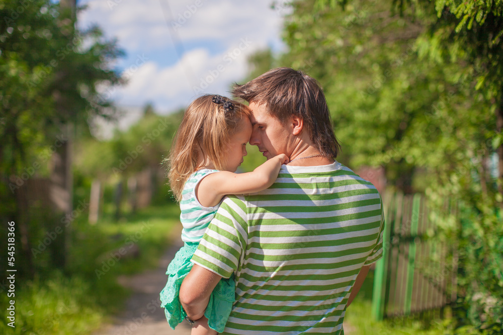 Naklejka premium A young father with a daughter in the village outdoors