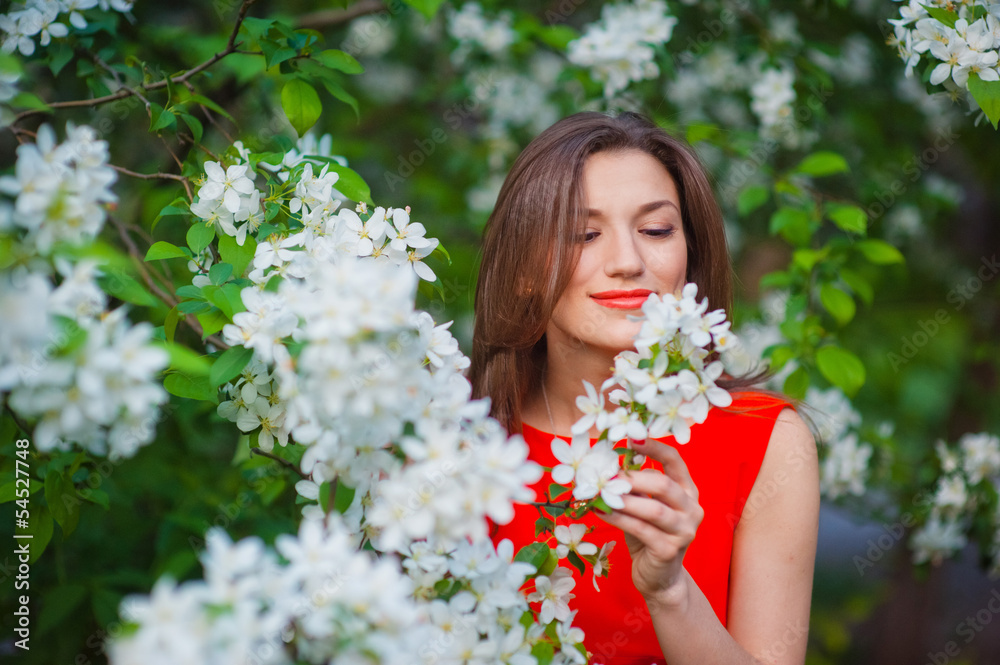 Young woman in red dress walking in garden Young woman in red dress walking in garden