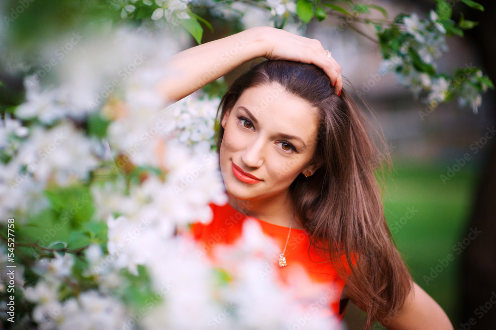 Young woman in red dress walking in garden Young woman in red dress walking in garden