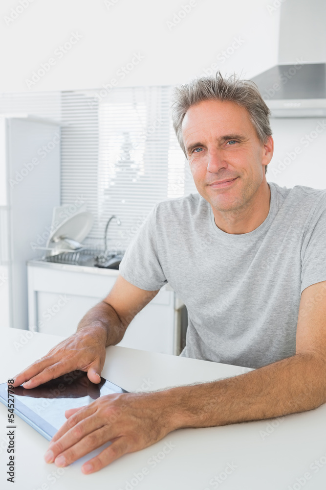 Cheerful man using tablet pc in kitchen Cheerful man using tablet pc in kitchen
