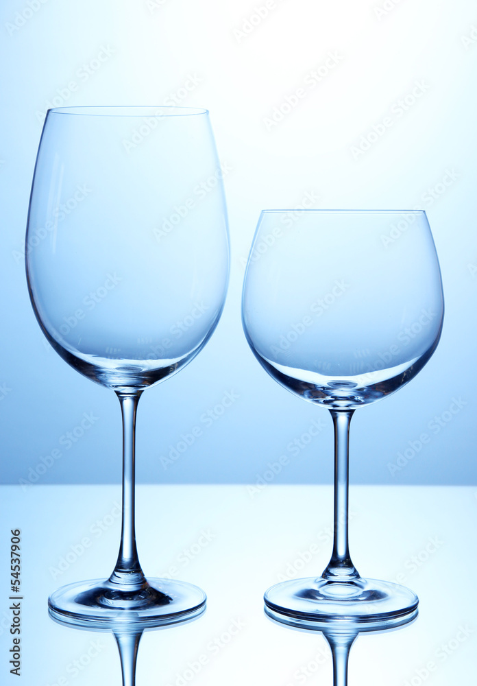 Empty wine glasses arranged on blue background