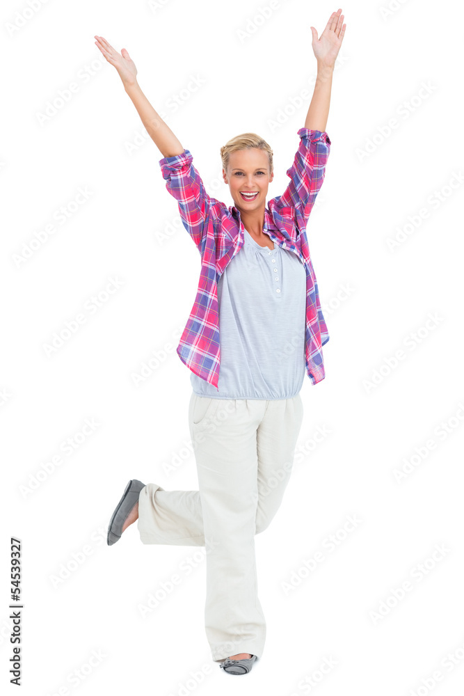 Excited woman standing with hands and foot up in air Excited woman standing with hands and foot up in air