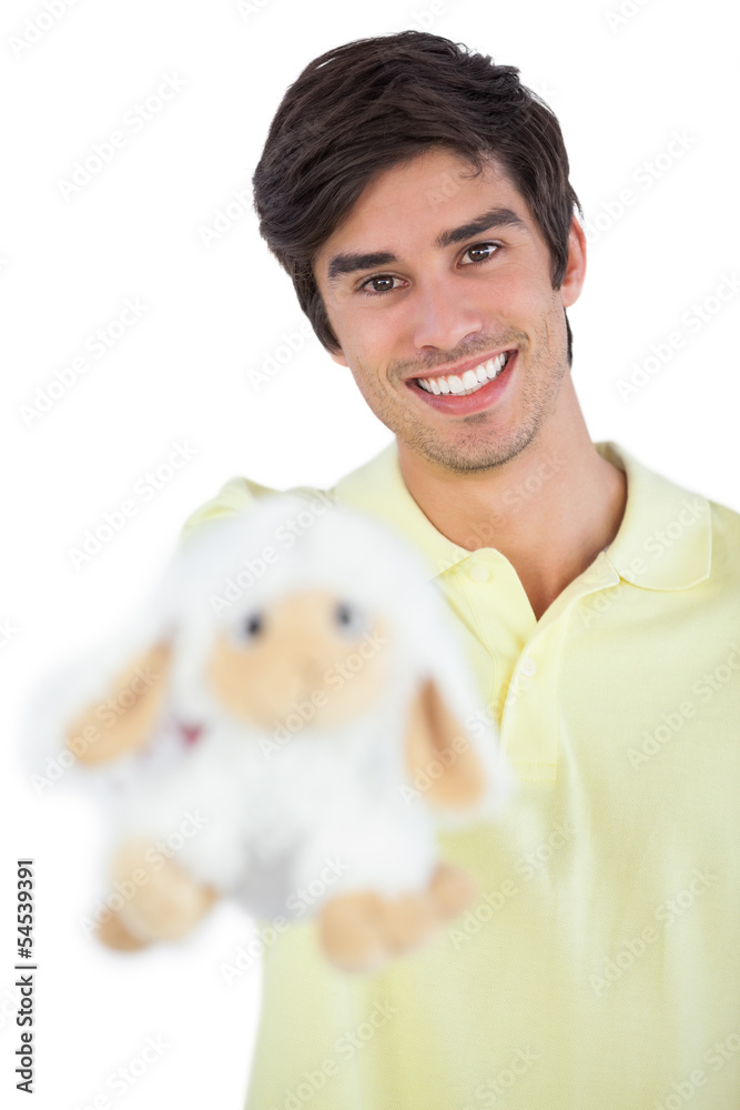 Young man holding sheep plush Young man holding sheep plush
