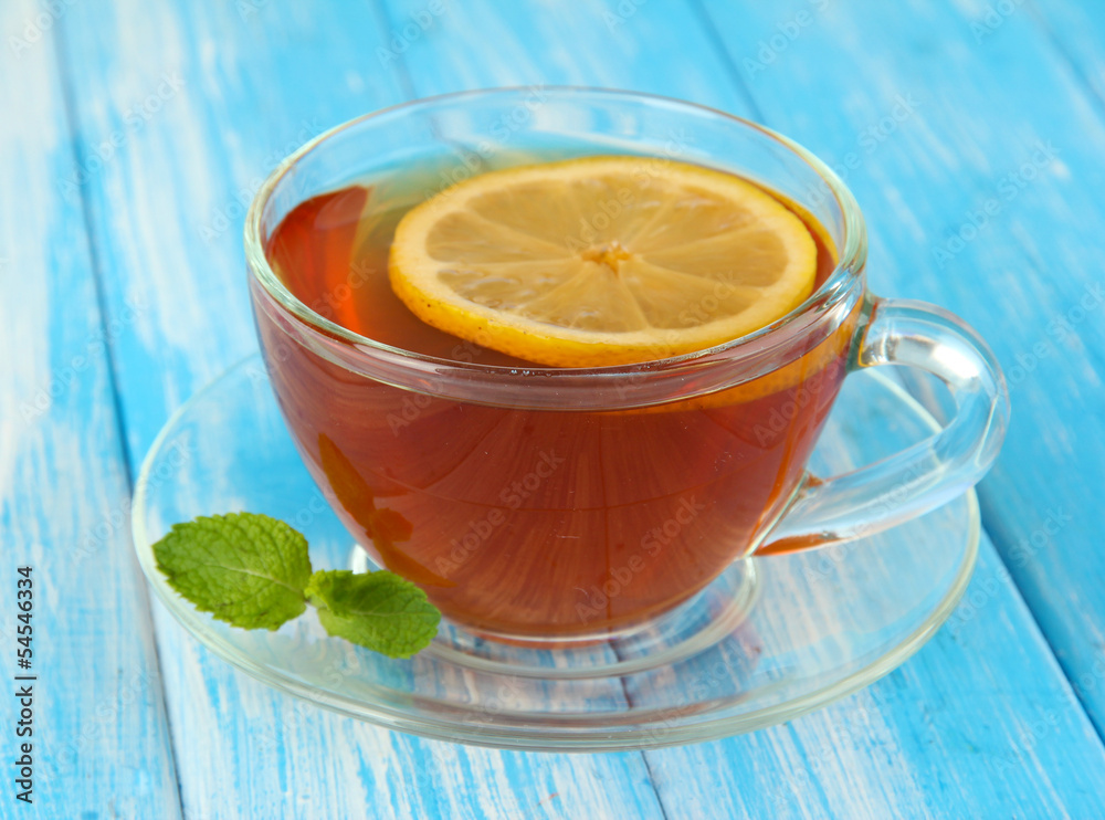 Cup of tea with lemon on table on blue background Cup of tea with lemon on table on blue background