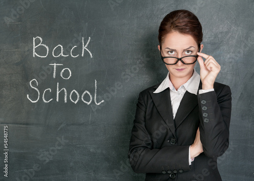 Teacher and phrase Back to school on the school blackboard
