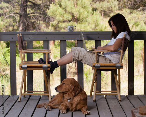Woman relaxing with laptop computer and dog