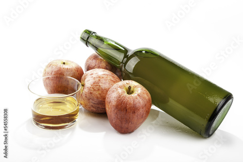 manzanas junto a una botella de sidra natural photo