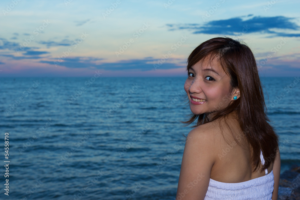 Woman smiling on seaview background in twilight Woman smiling on seaview background in twilight