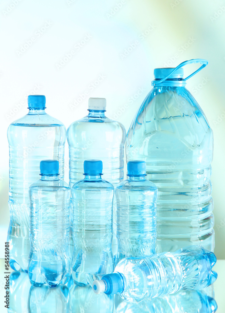 Water in different bottles on light background Water in different bottles on light background