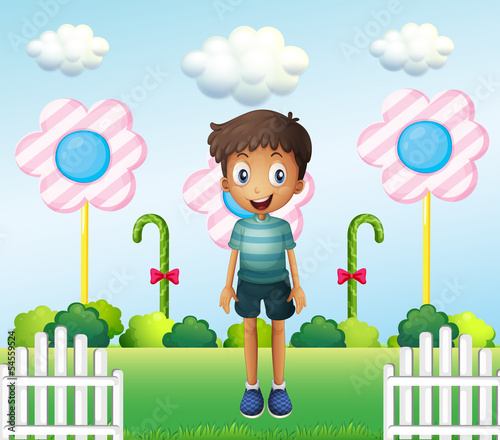 A boy in the garden with flower lollipops