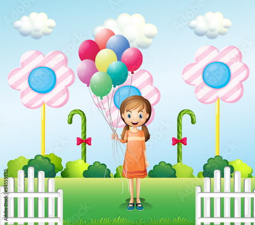 A girl holding balloons in the garden