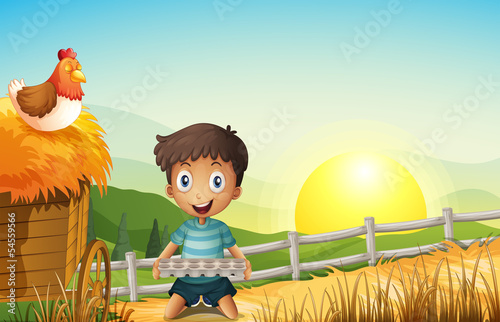 A boy in the farm holding an empty egg tray photo