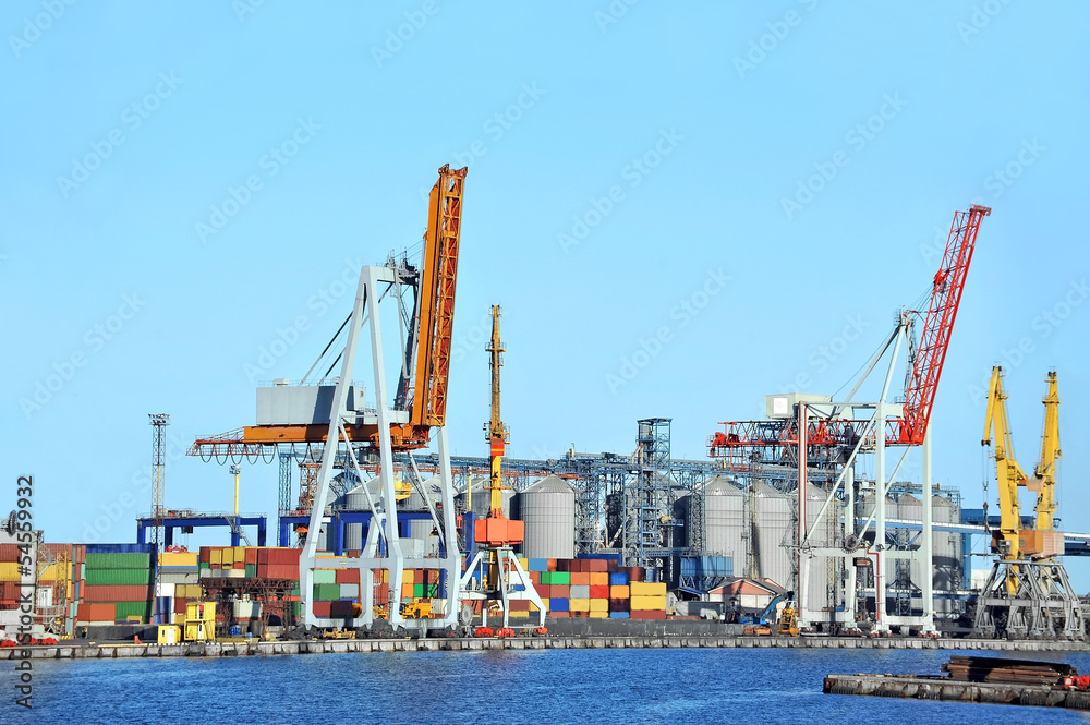 Port cargo crane and container over blue sky background