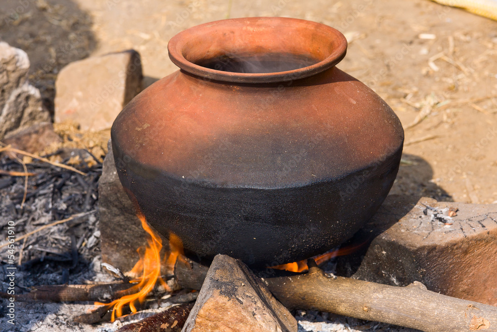 Clay pot with food on fire, India Clay pot with food on fire, India