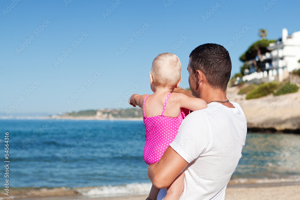 Happy father and his little daughter at beach