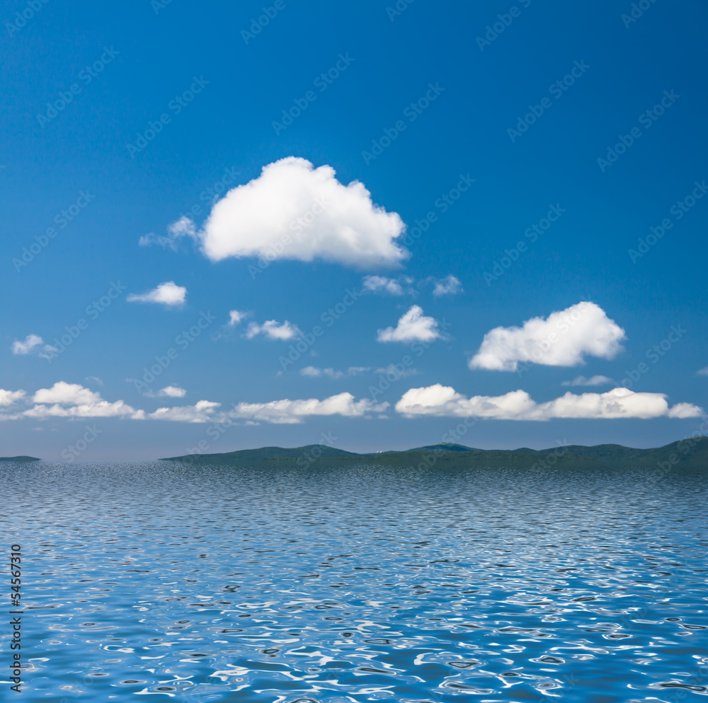 Sky with clouds reflected in water surface.
