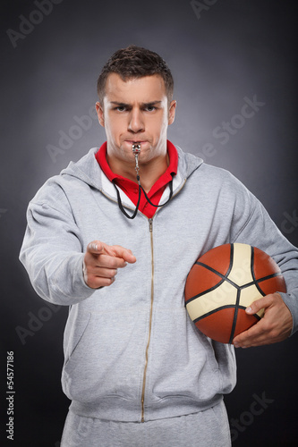 Displeased trainer. Portrait of angry young coach whistling and