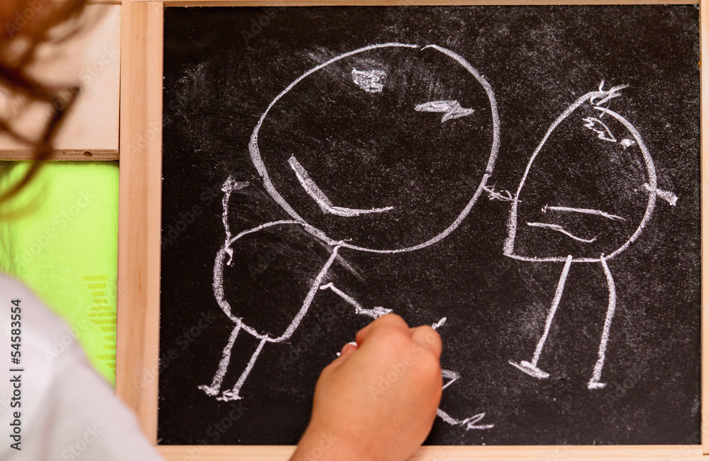 Little girl drawing on blackboard