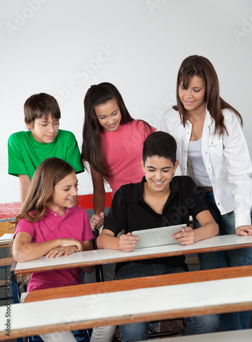 Students Using Digital Tablet At Desk
