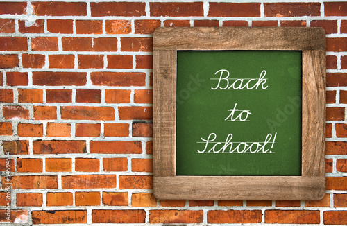 chalkboard over red brick wall background © LiliGraphie