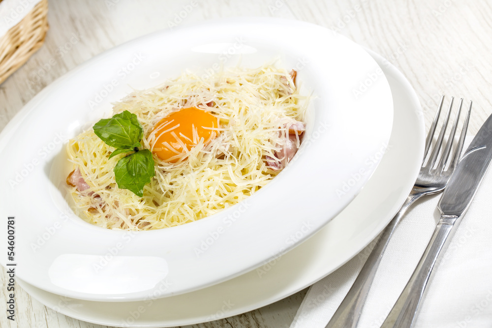 spaghetti with egg on a table in a restaurant