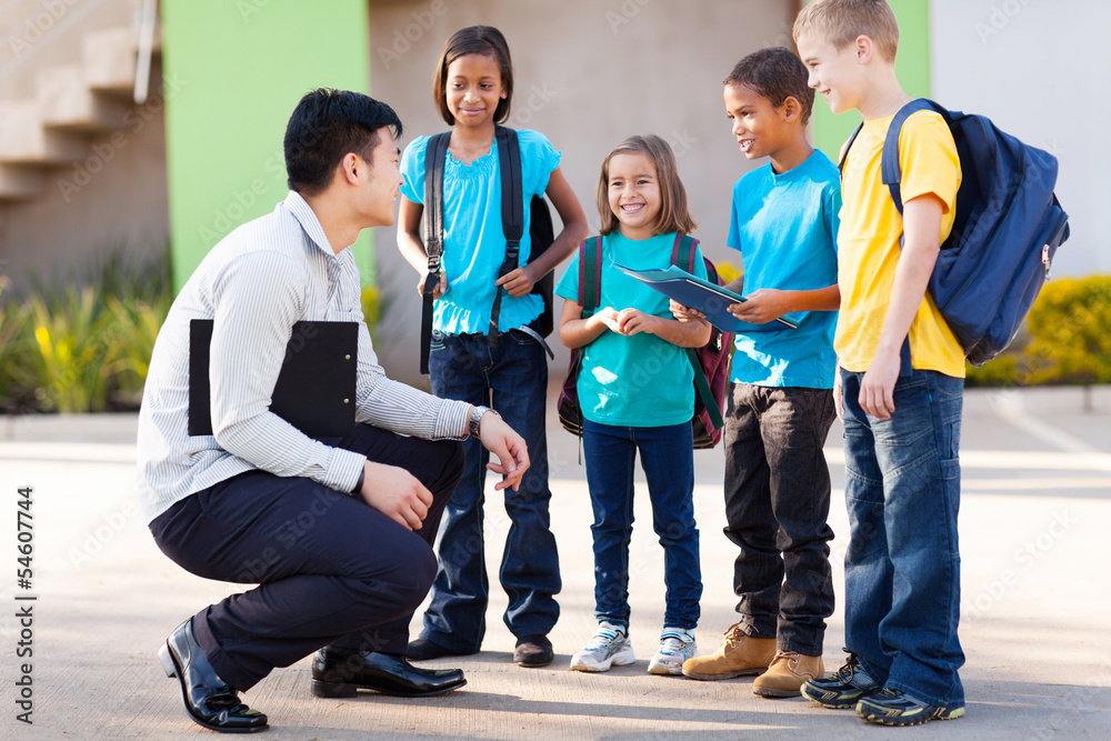 Fototapeta premium elementary pupils outside classroom talking to teacher