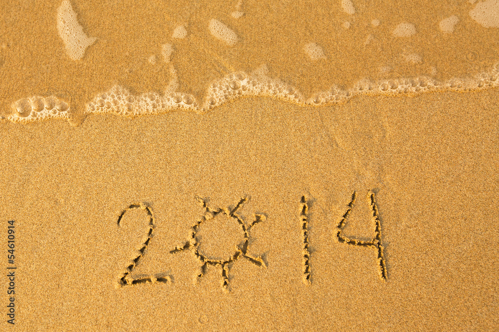 2014 - written in sand on beach texture - soft wave of the sea.