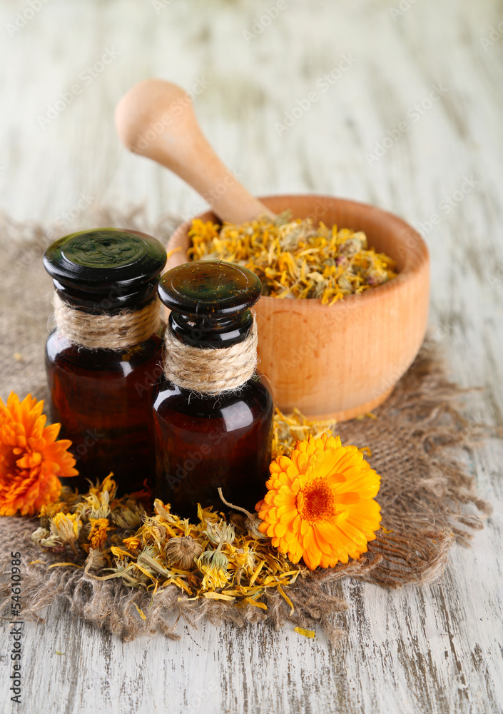 Medicine bottles and calendula flowers on wooden background Medicine bottles and calendula flowers on wooden background