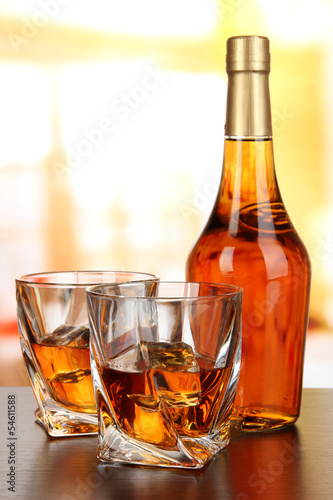 Glass of whiskey with bottle, on dark background