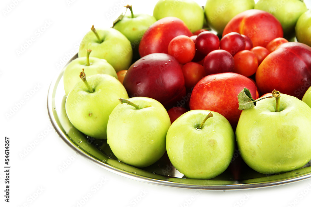 Assortment of juicy fruits on plate, isolated on white