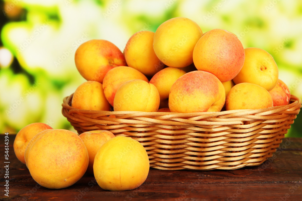 Fresh natural apricot in wicker basket on wooden table