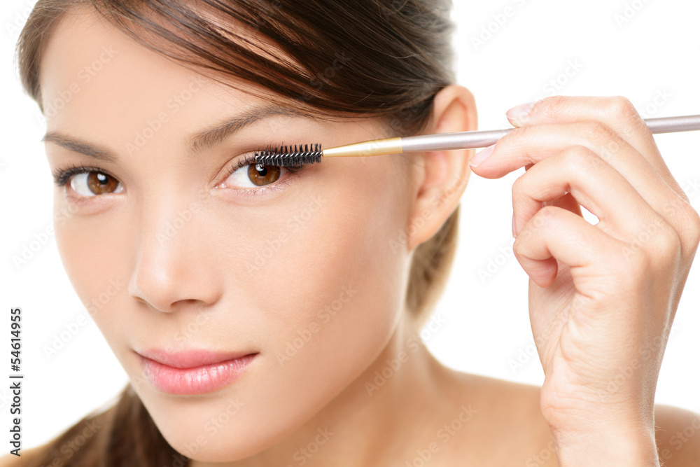 Mascara woman putting makeup on eye closeup