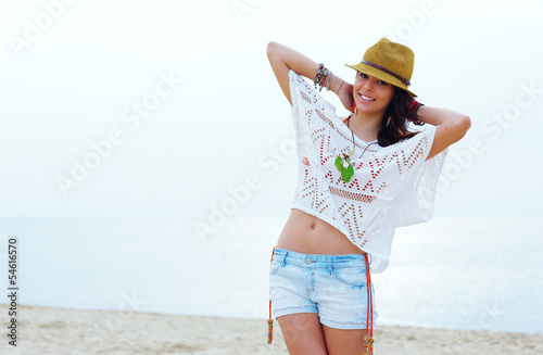 Young woman in stylish outfit walking on the the beach © Drobot Dean