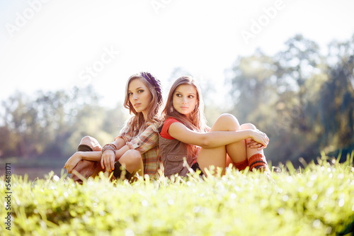 two girls sitting back to back