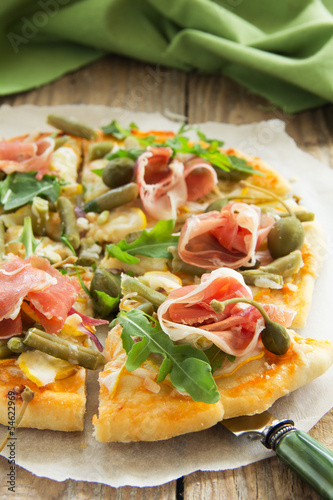 Pizza with arugula and prosciutto.