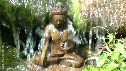 Buddha seated under a waterfall photo