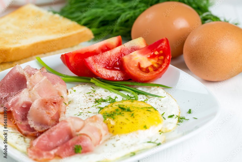 Fried eggs with ham and tomatoes