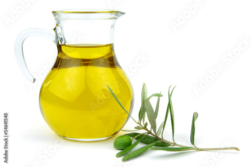 Olive Oil in glass carafe and green olive branch