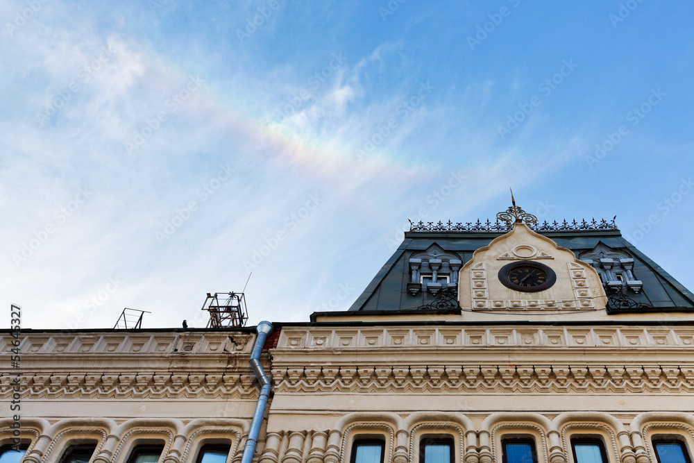 Rainbow in blue sky over building