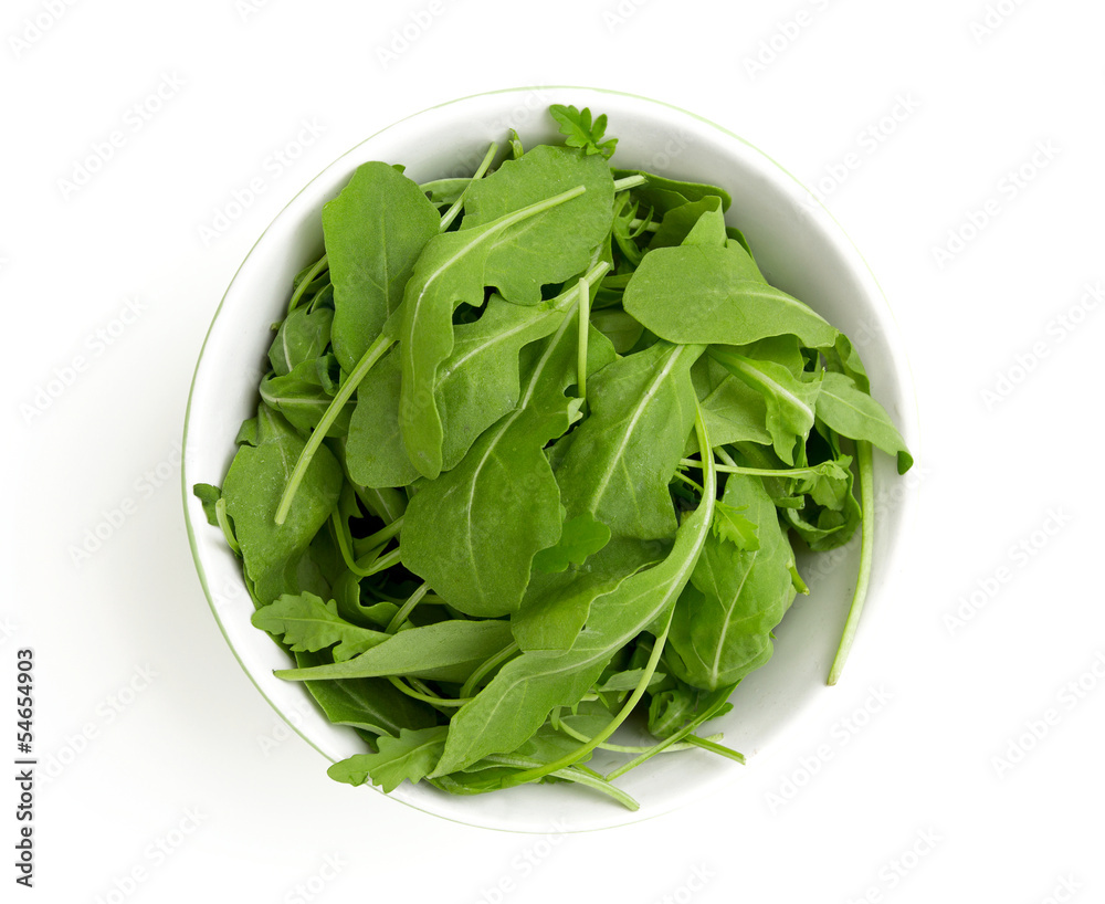 rucola in a glass bowl isolated on white background