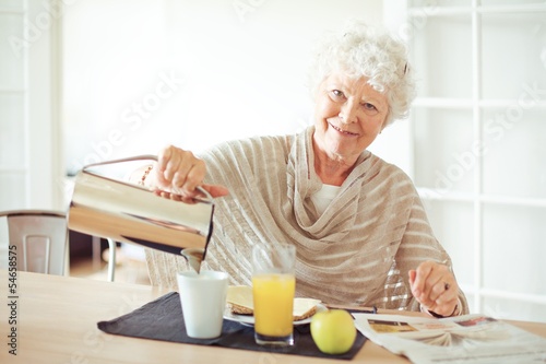 Cheerful Grandma at Home Having Breakfast