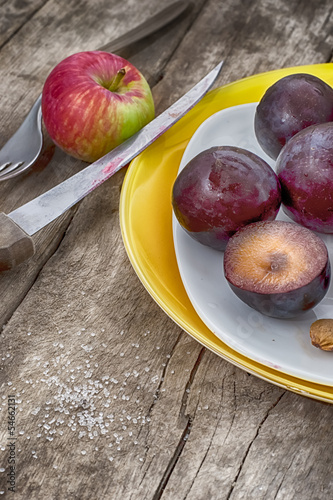 Ripe plums on a wooden background