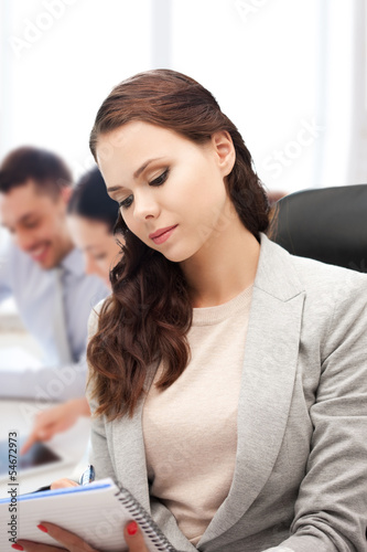 attractive businesswoman taking notes in office
