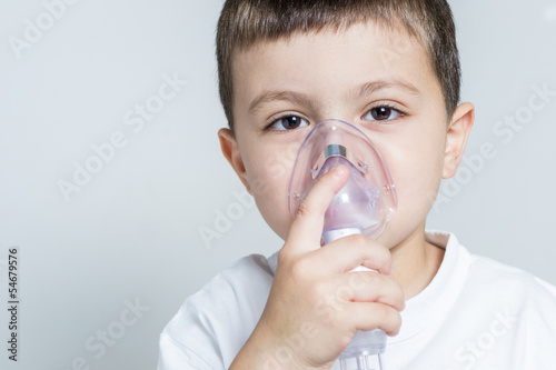 Little boy having inhalation for easing cough
