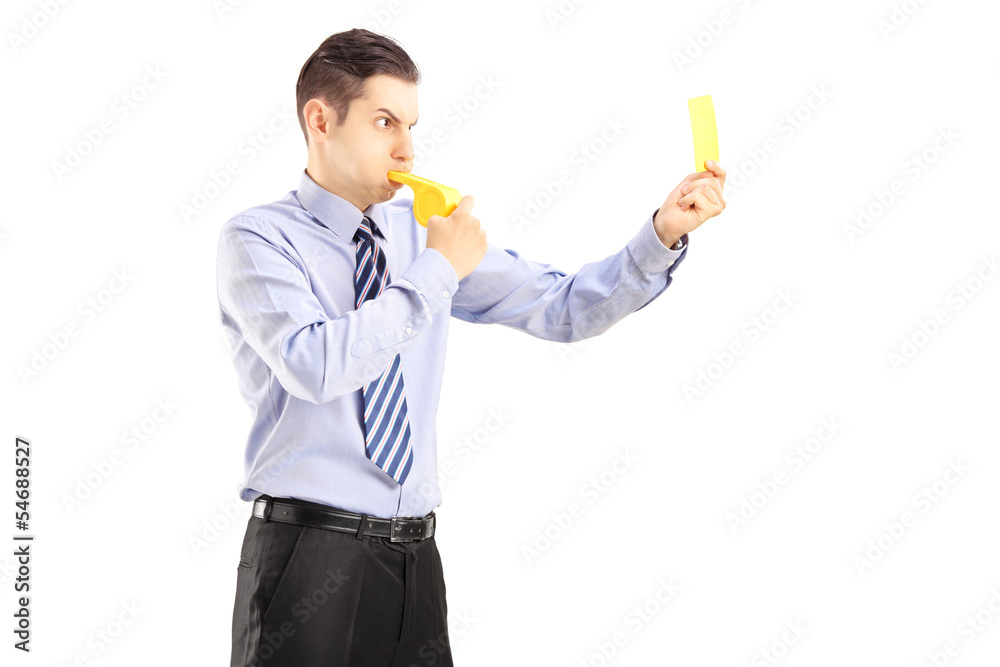 Young man blowing a whistle and showing a yellow card Young man blowing a whistle and showing a yellow card