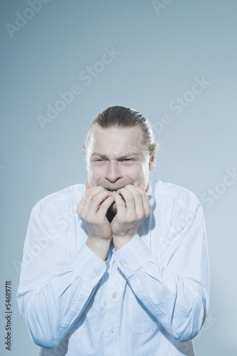anxious man chewing on fingernails