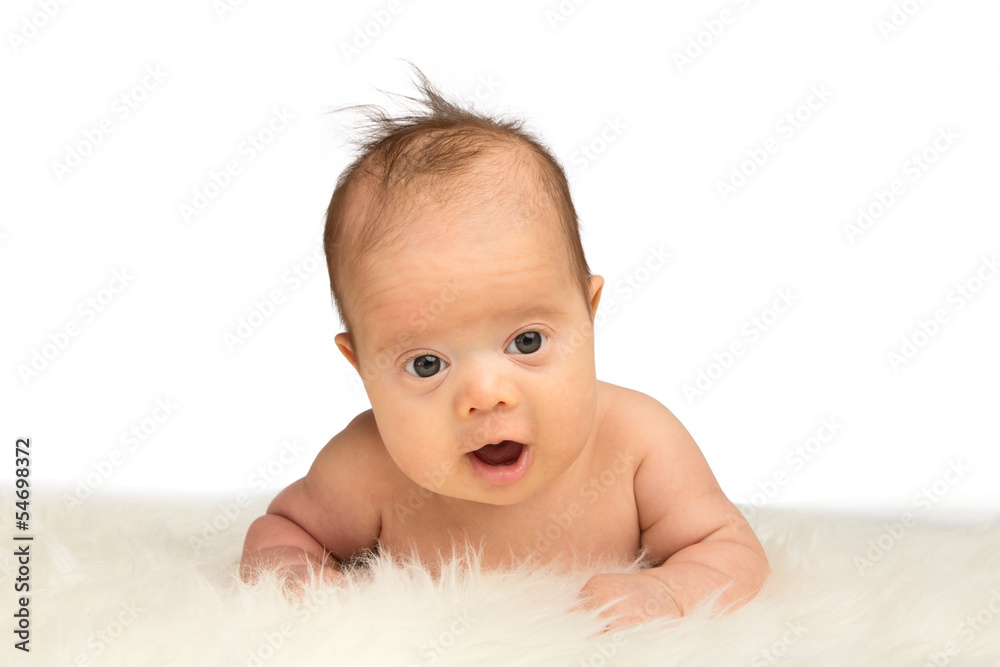 Little baby girl Lying on her belly on a sheepskin and holding h Little baby girl Lying on her belly on a sheepskin and holding h