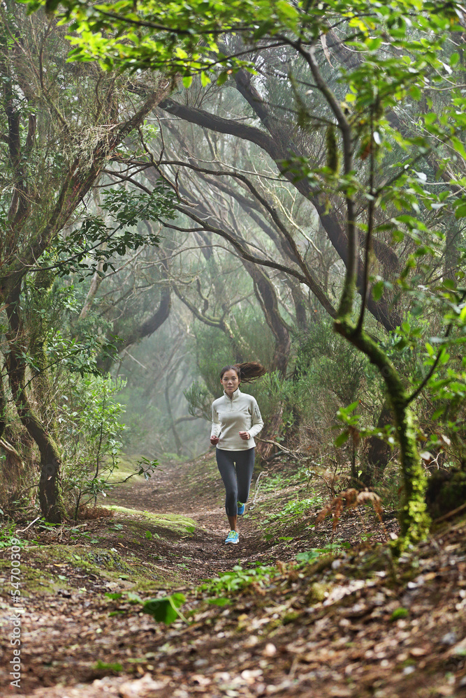 Runner woman cross-country running in forest Runner woman cross-country running in forest