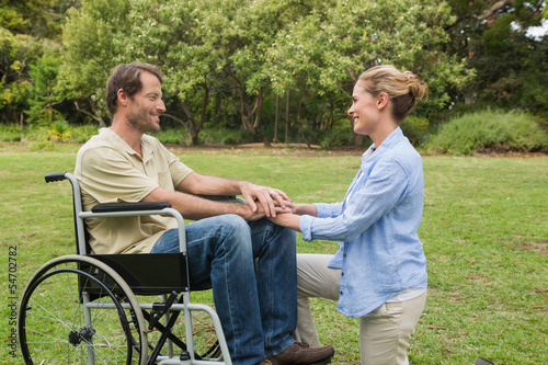 Smiling man in wheelchair with partner kneeling beside him © WavebreakmediaMicro