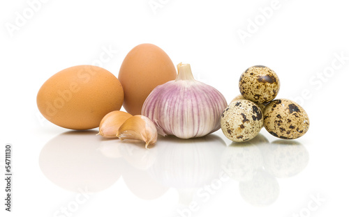 chicken eggs, garlic and quail eggs on a white background